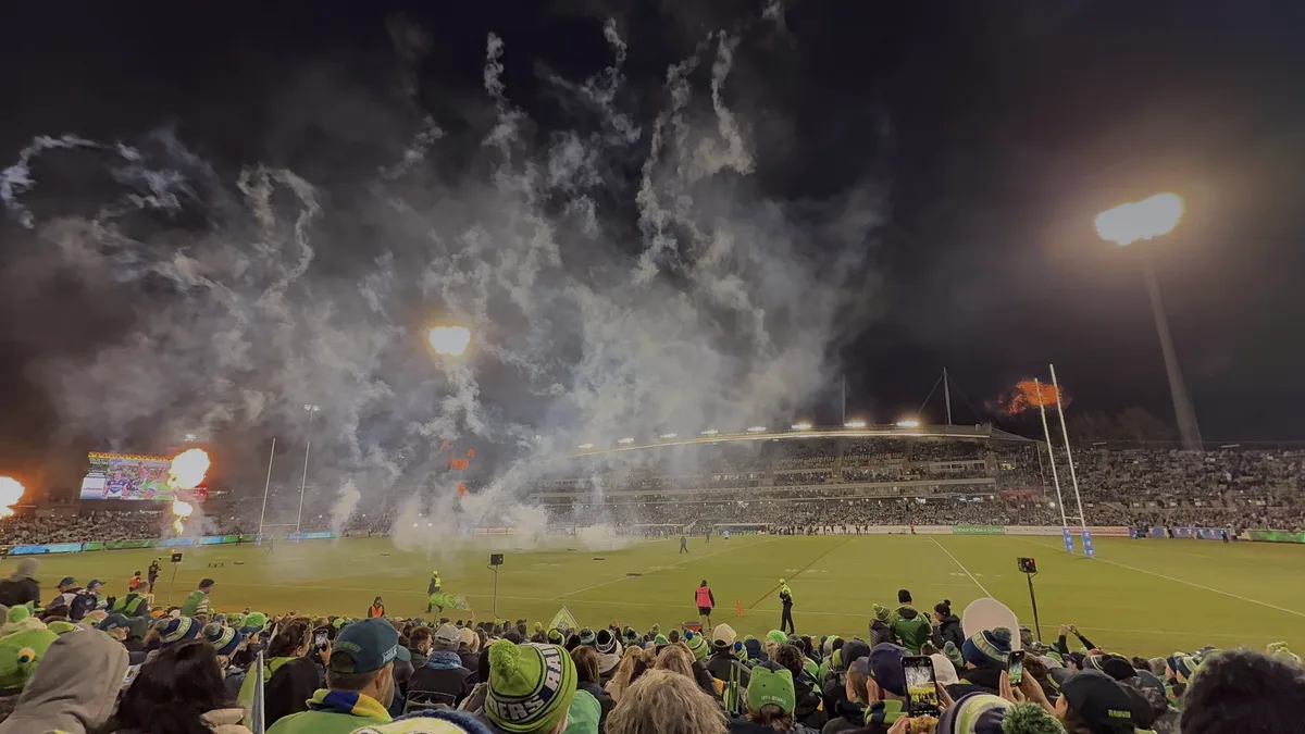 Fan loyalty app on a smartphone showing post-game engagement streaks in a sports clubhouse