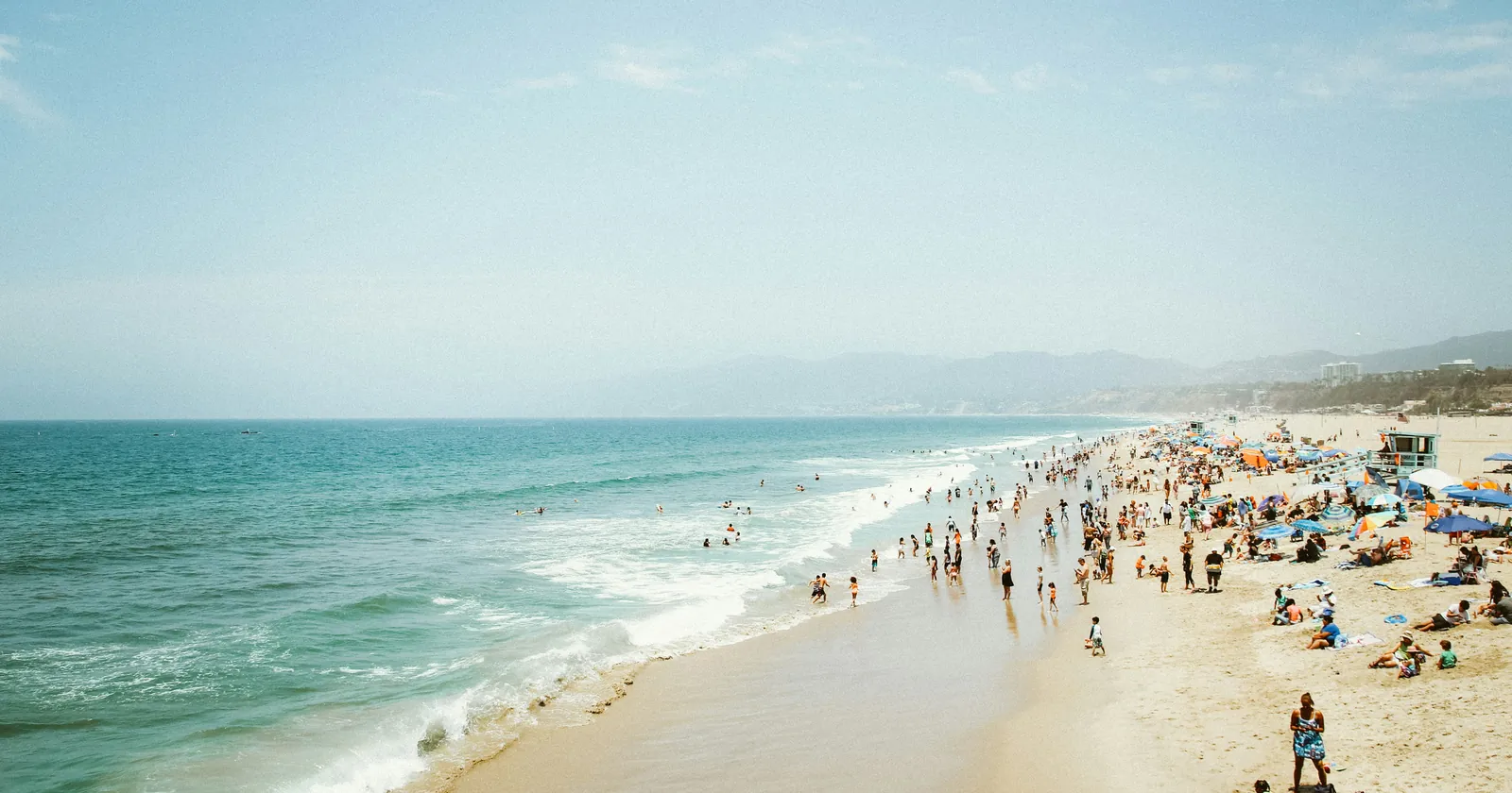 Visitors crowded onto one stretch of beach, the pattern a day-trip economy makes.